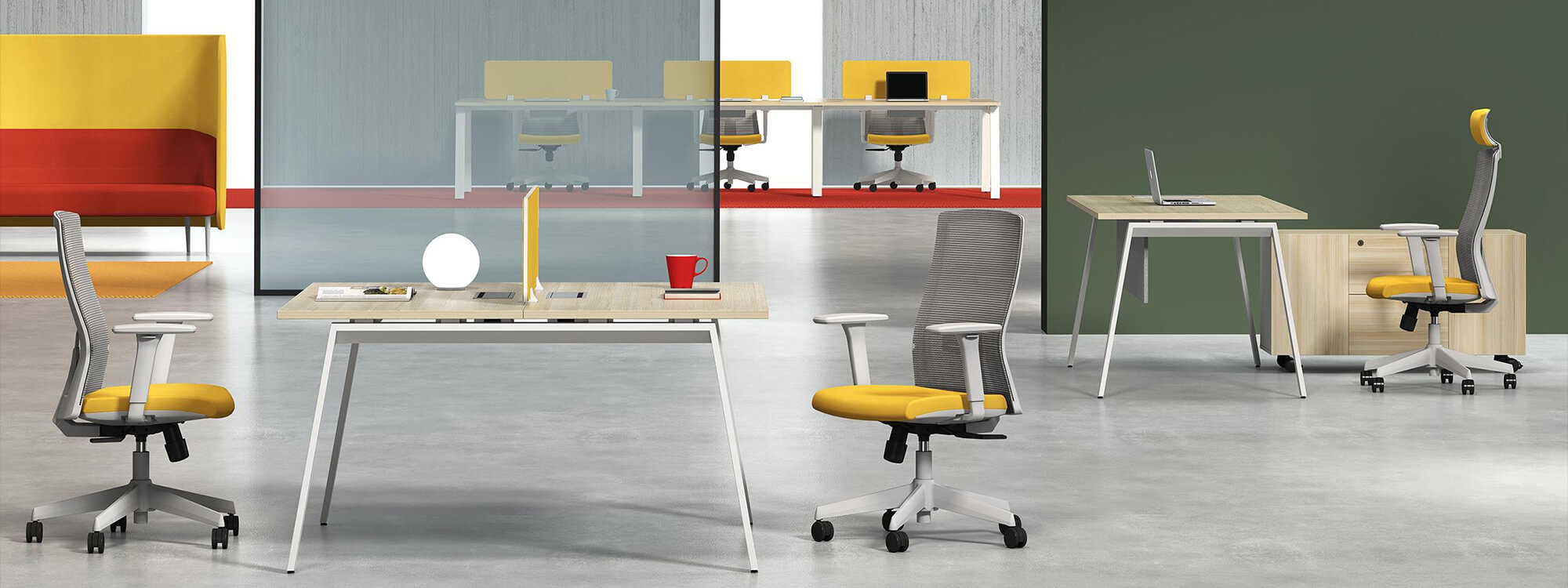 В офисе двухместное рабочее место рядом с офисным креслом с желтой подушкой.