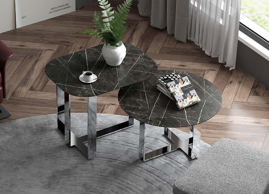 Чашка кофе, горшок с зелеными растениями и несколько книг стоят на грифельном круглом журнальном столике со стальным уголком.